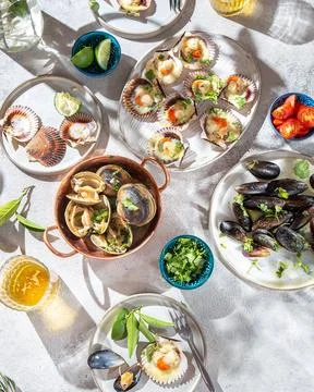 Seafood seashell. Summer table with baked ostions, clams and mussels with c.. Stock Photos