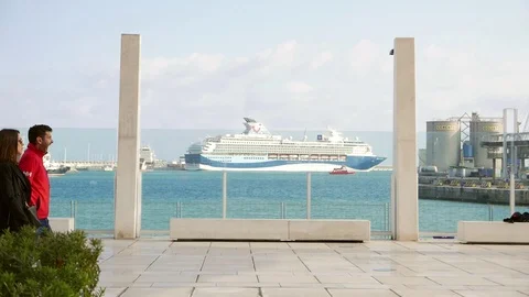 Seafront promenade with a ferry in the background behind a glass window Stock Footage 106338317
