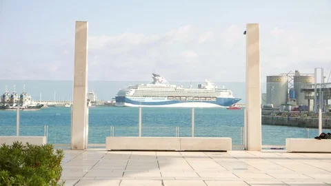 Seafront promenade with a ferry in the background behind a glass window Stock Footage 106338818