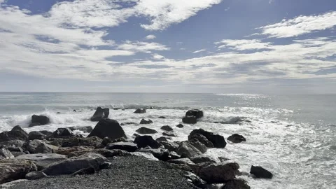 Seagull on a cliff in Ventimiglia with the sun reflecting off the sea and clouds Видео 320252293