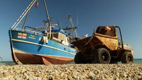 A Seagull rests on a dumpster next to Hastings fishing boat 6K Stock Footage 330151432