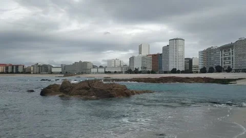 Seagulls perched on rocks at Riazor beach in A Coruna Stock Footage 148054698