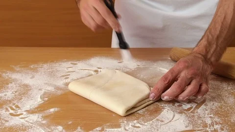 Seal edges by pressing down with rolling pin and brush off excess flour. Stock Footage 77223026