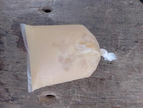 Sealed liquid filled plastic packet, creamy light peach colored liquid Stock Photos