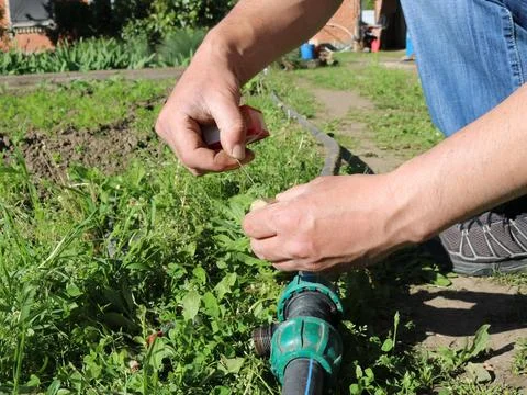 Sealing a fitting thread with plumbing thread in a garden setting Stock Photos
