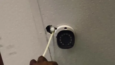 Sealing Wall Hole Under CCTV Camera With Expanding Foam For Pest Control Stock Footage 346909251