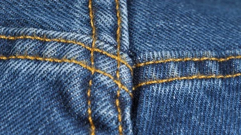 Seam on denim jeans, tracking macro. Denim textile texture, close up low angle Stock Footage 121378149