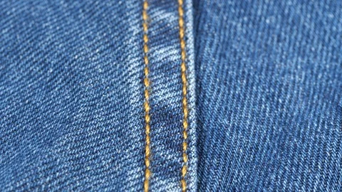 Seam on denim jeans, tracking macro. Denim textile texture, close up low angle Video stock 121378219