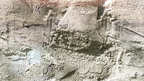 Seamless 4K looping vertical movement over a rough plaster wall with handcrafted Video stock 344123478