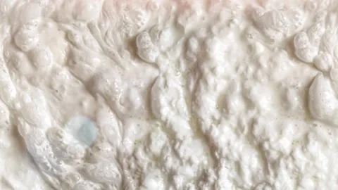 Seamless 4K looping vertical movement across a creamy white foam texture with Stockbeeldmateriaal 344124643