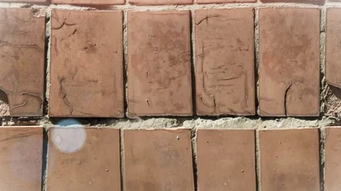 Seamless 4K looping vertical movement over aged terracotta floor tiles with Stock Footage 344124940
