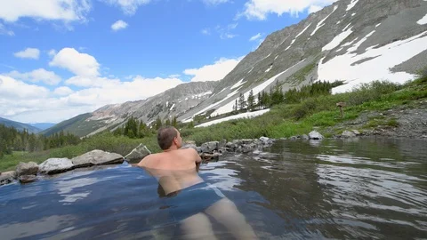 Seamless cinemagraph loop of man swimming in hot springs in Colorado summer Stock Footage 130073141