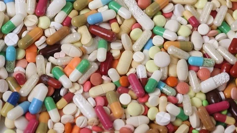 Seamless closeup loop of colorful pills in a pile rotating Video stock 124636356