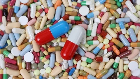 Seamless closeup loop shot of big pills on top of pile of small ones Stock Footage 123479271