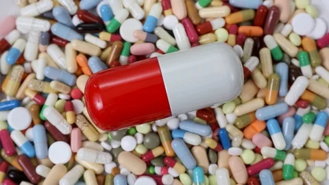 Seamless closeup loop shot of big pill on pile of medication Stock Footage 124121905