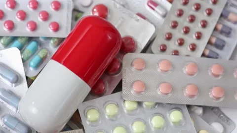 Seamless closeup loop shot of big pill on top of blisters of medication Stock Footage 147200206