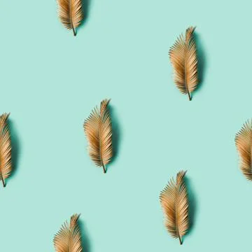 Seamless creative texture. Golden painted tropical leaf on pastel backgrou... Stock Photos
