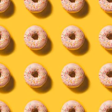 Seamless Doughnut Pattern on bright illuminating background Stock Photos