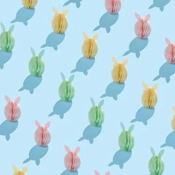 Seamless Easter pattern with pastel paper bunnies and shadows on a light blue Stock Photos