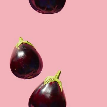 Seamless Eggplants Pattern on a pink background. Many Aubergines. Wallpaper Foto stock