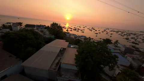Seamless FPV Drone Descent from Hillside Over Fishing Village to Ocean at Sunset Vídeos de archivo 331585171