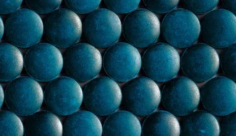 A seamless hexagonal pattern of many blue organic spirulina tablets laid tigh Stock Photos