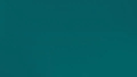 Seamless loop background in 4K featuring a textured teal surface with subtle Stock Footage 299397352