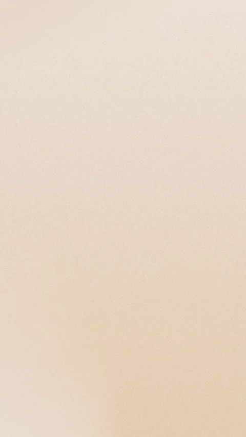 Seamless loop background in 4K with a soft beige gradient and subtle grain Stock Footage 309957110