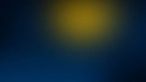 Seamless loop background with a blurred circular yellow glow on a dark blue Stock Footage 299664680
