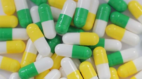 Seamless loop, background, intro. Rotation of white, yellow, green capsules Stock Footage 157238115