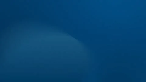 Seamless loop background with a soft blue gradient featuring a large, blurred Stock Footage 299664534