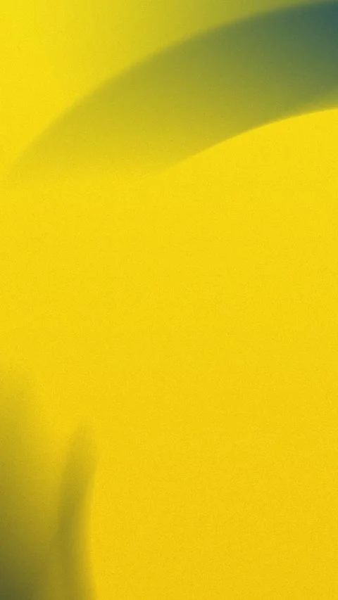 Seamless loop background with a yellow gradient and soft curved shadow. 4K. Stock Footage 309701324