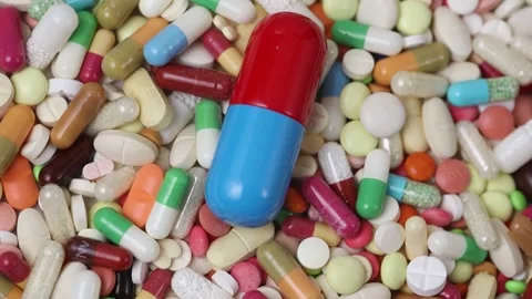 Seamless loop of big blue and red pill on pile of medicine Stock Footage 154309004