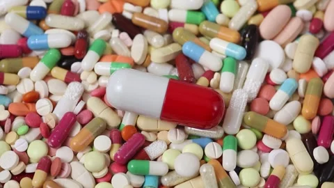 Seamless loop of big pill on top of pile of pills rotating counterclockwise Stock Footage 288107195
