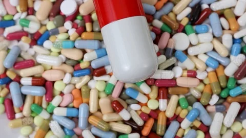 Seamless loop of big red and white pill on pile of medication Stock Footage 124636378