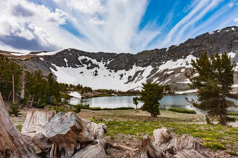 Seamless loop of billowing roiling clouds racing over ridge and alpine lake Stock Footage 115192909