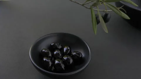 Seamless loop of black olives in black bowl copy space low key 4k 스톡 동영상 340936971