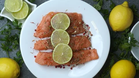 Seamless loop of citrus topped salmon with parsley rotating on white plate .. Stock Footage 321234197