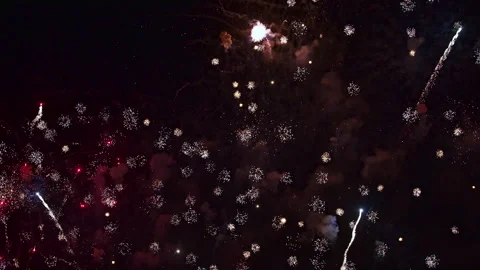 Seamless loop of colorful red, white, gold and green fireworks bursting and Stock Footage 347869032