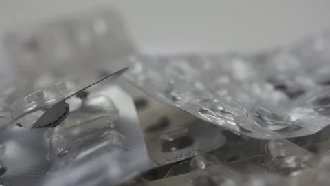 Seamless loop of empty and used medicine blisters rotating Stock Footage 124121945