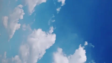 Seamless loop of fluffy clouds in a blue sky in a summer shot on a clear Video stock 228668856