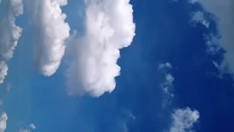 Seamless loop of fluffy clouds in a blue sky in a summer shot on a clear Video stock 228668909