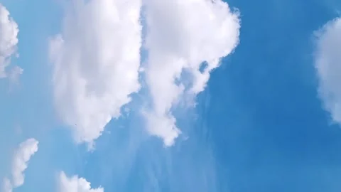 Seamless loop of fluffy clouds in a blue sky in a summer shot on a clear Video stock 228672504
