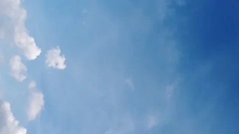 Seamless loop of fluffy clouds in a blue sky in a summer shot on a clear Video stock 228673502
