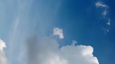 Seamless loop of fluffy clouds in a blue sky in a summer shot on a clear Video stock 228673504