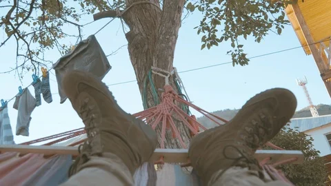 Seamless loop of a man in first person perspective lying in a hammock on a Stock Footage 106542740