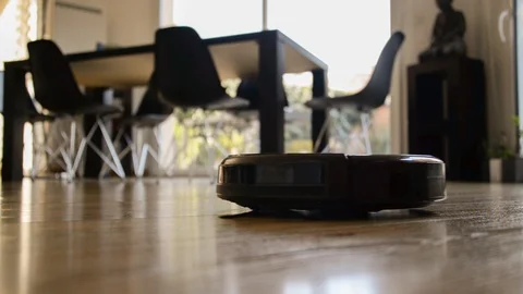 Seamless loop of a robot vacuum cleaner moving on a wooden floor Stock Footage 105027540