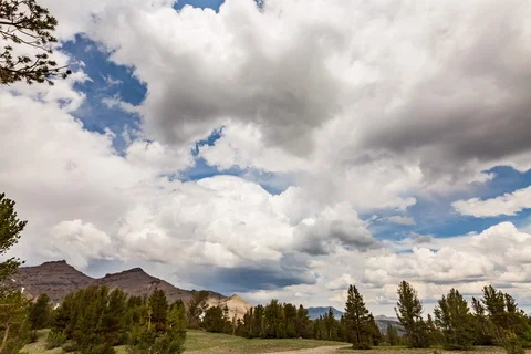 Seamless loop of roiling clouds over alpine meadow Stock Footage 115211382