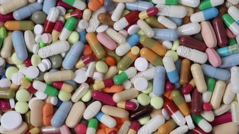 Seamless loop shot of colorful pills in a pile rotating Stock Footage 154309007