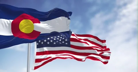 Seamless loop in slow motion of colorado and US flags waving on a clear day Stock Footage 243091101